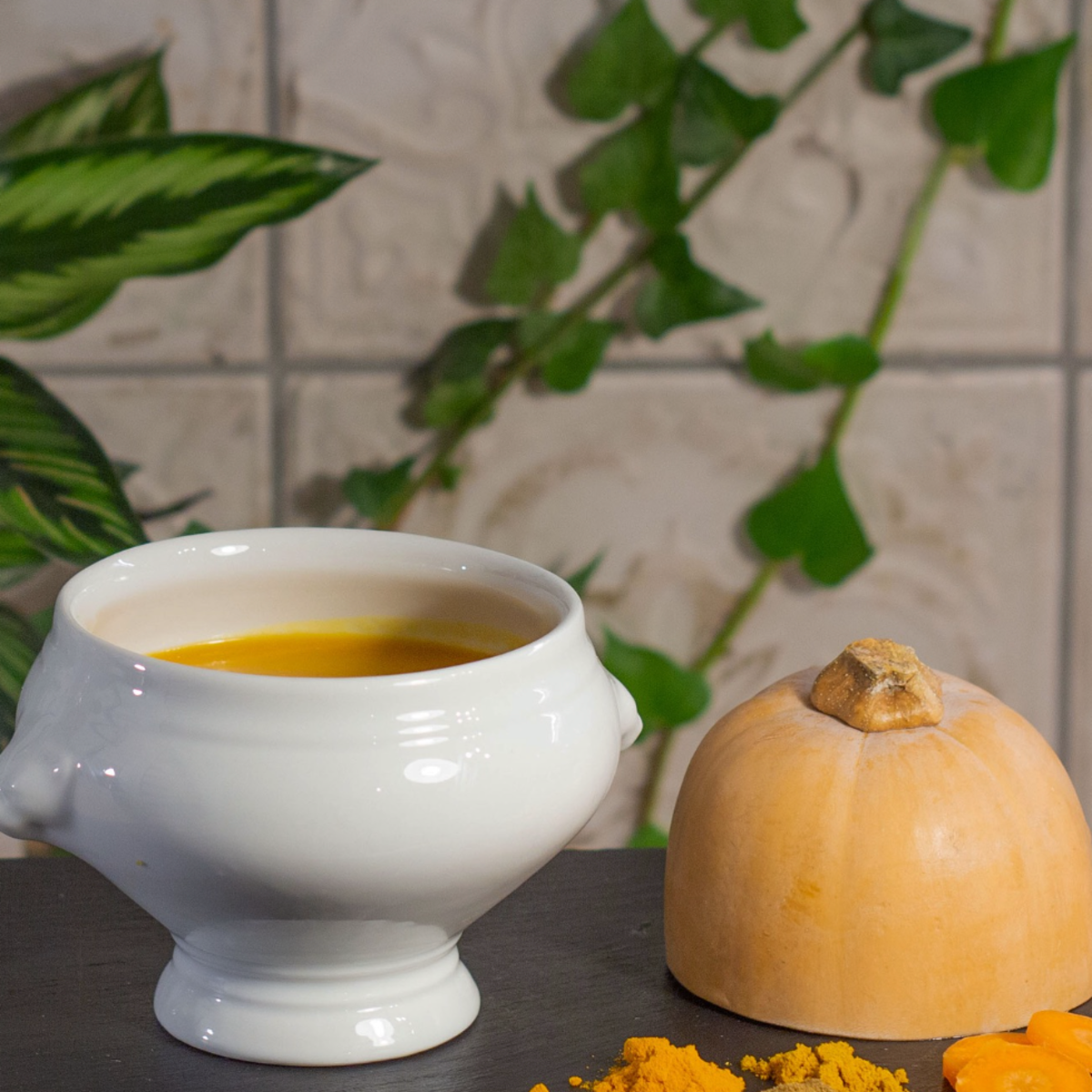 Soupe de potiron au curcuma servie dans une soupière blanche